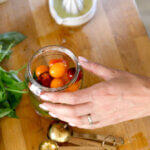 placing the cherry tomatoes in a jar